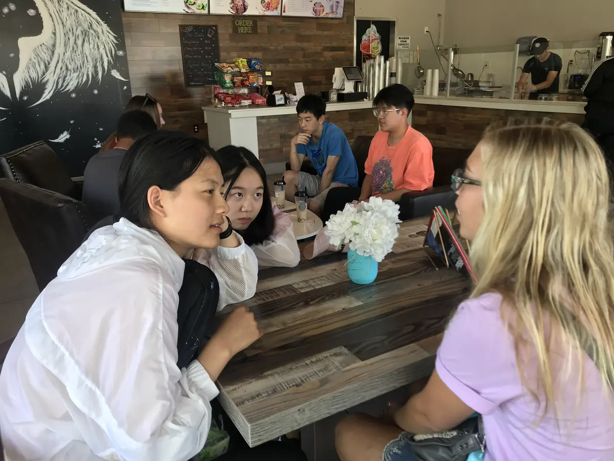 中外学生在餐厅围桌交流的真实活动场景