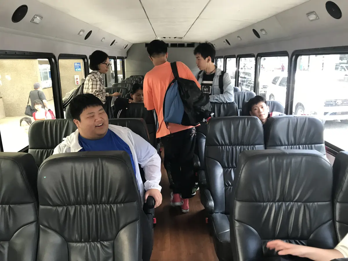 中国学生团队乘坐接驳车辆前往学校或住宿地点