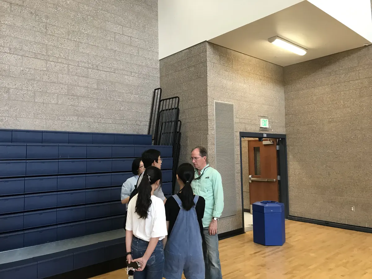 中国学生在美国学校体育馆活动后与教师交流