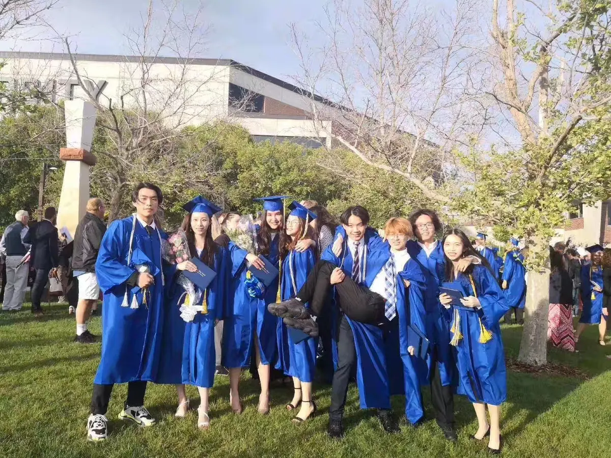 中国学生身着毕业服在美国学校毕业典礼合影