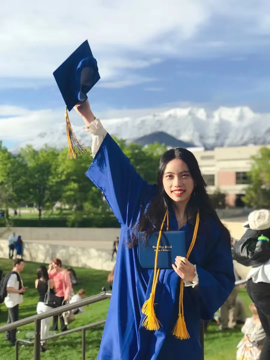 中国学生穿毕业服在美国学校毕业典礼后留影