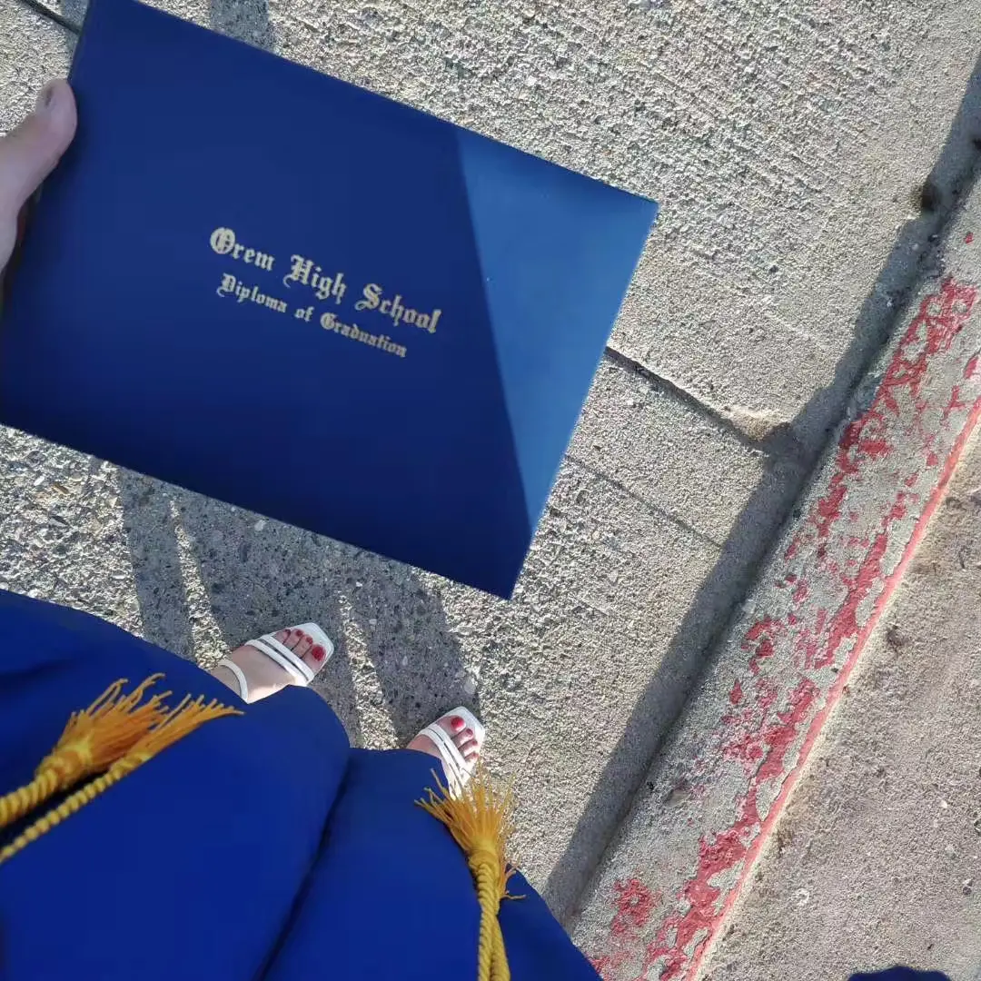 中国学生手持 Orem High School 毕业证书记录毕业时刻