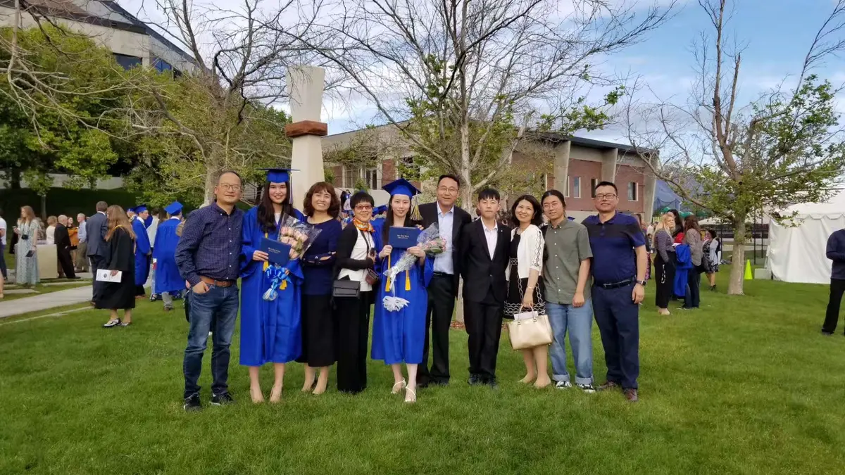 中国学生在美国高中毕业典礼后与老师和同学集体合影