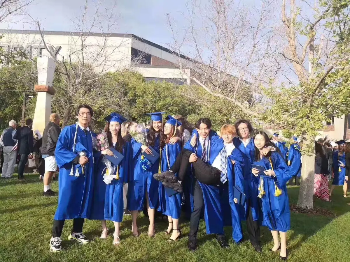 中国学生在美国高中毕业典礼后穿毕业服集体合影