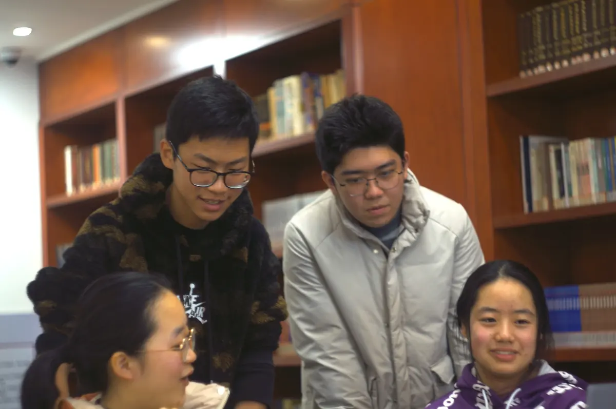 学生在图书馆或教室内围绕电脑参加双向课堂讨论