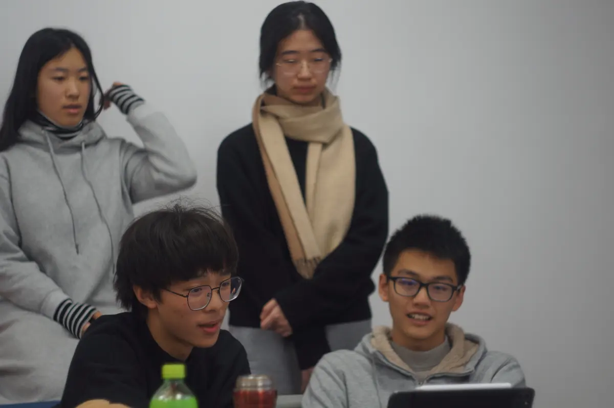 学生围绕电脑参加双向课堂小组讨论