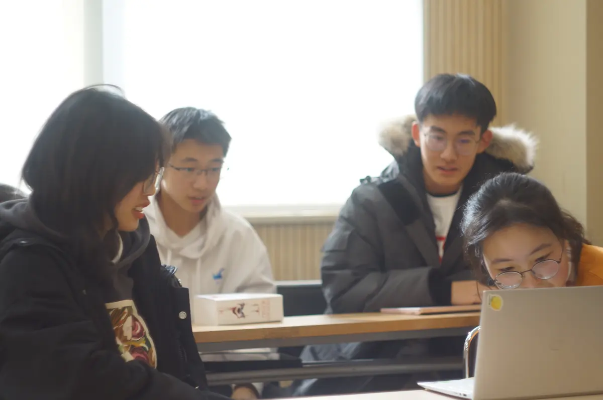 学生围绕电脑参加双向课堂小组学习