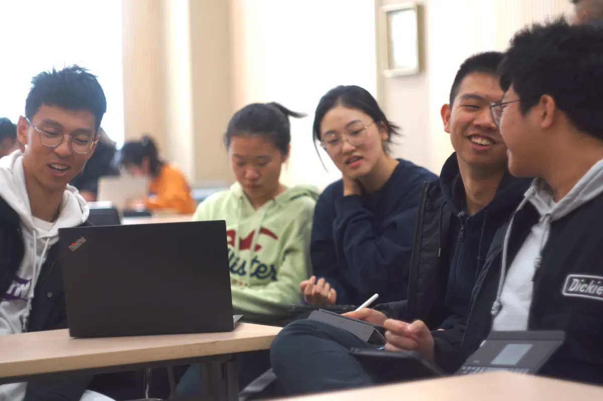 学生围绕电脑参加双向课堂小组学习