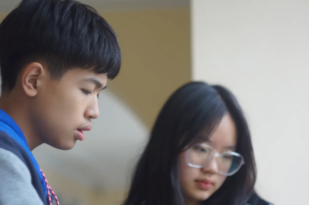 两名学生在课堂内使用电脑参加双向学习活动