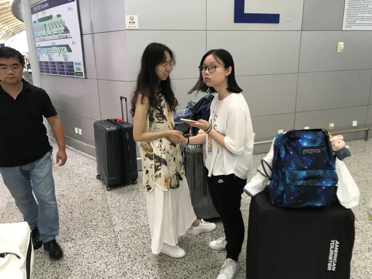 学生在美国机场携带行李交流