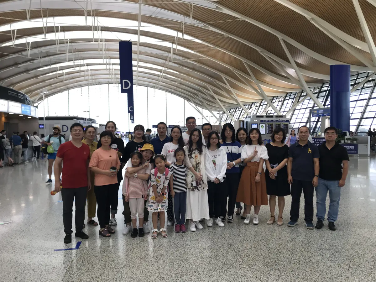 学生与项目人员携带行李在美国机场合影