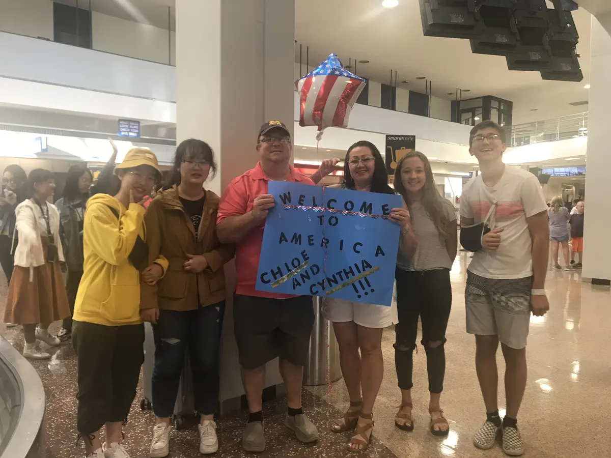 学生抵达美国后手持中英文欢迎标语合影
