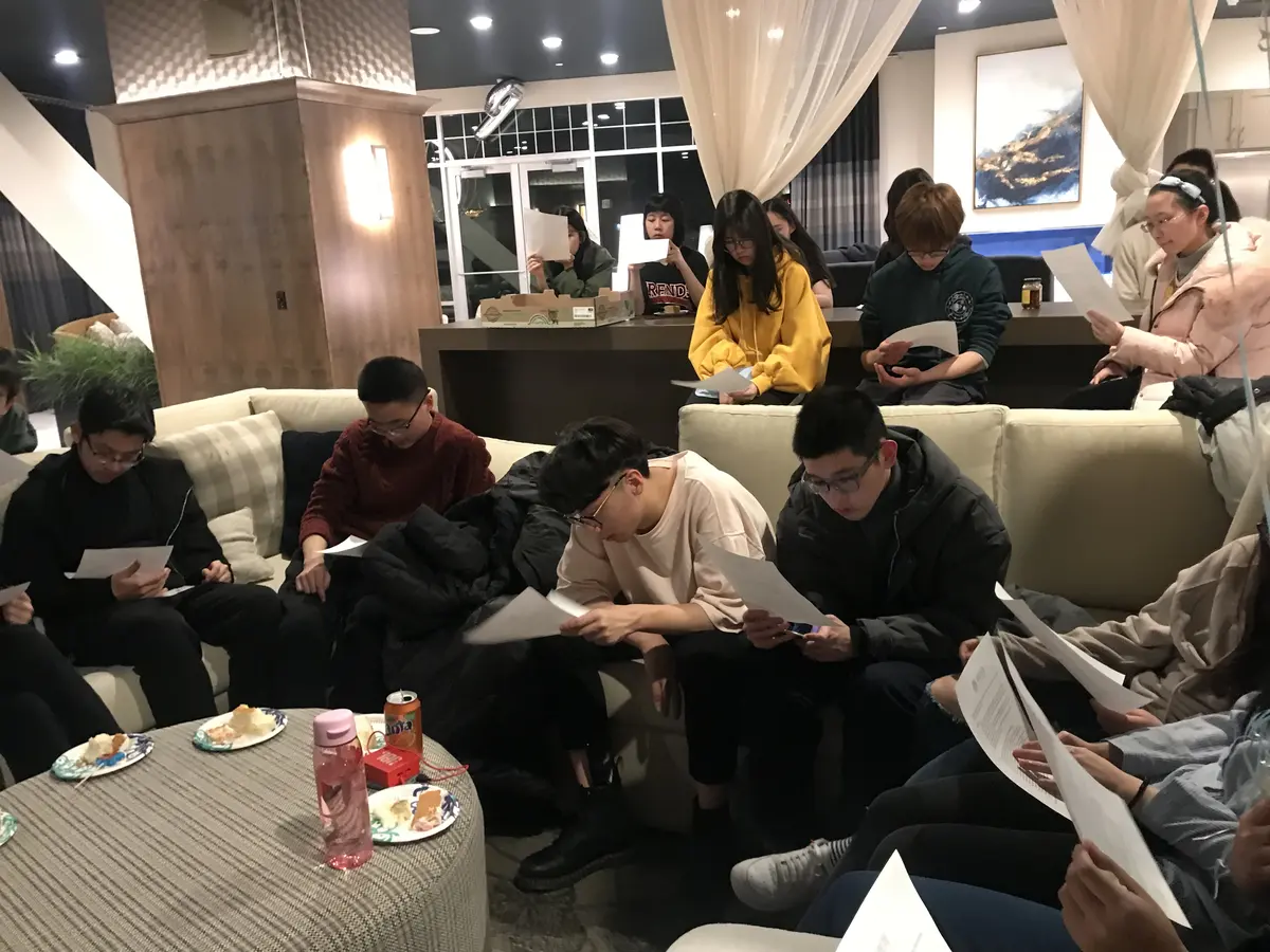 学生在美国餐厅或公共空间共同填写资料并交流