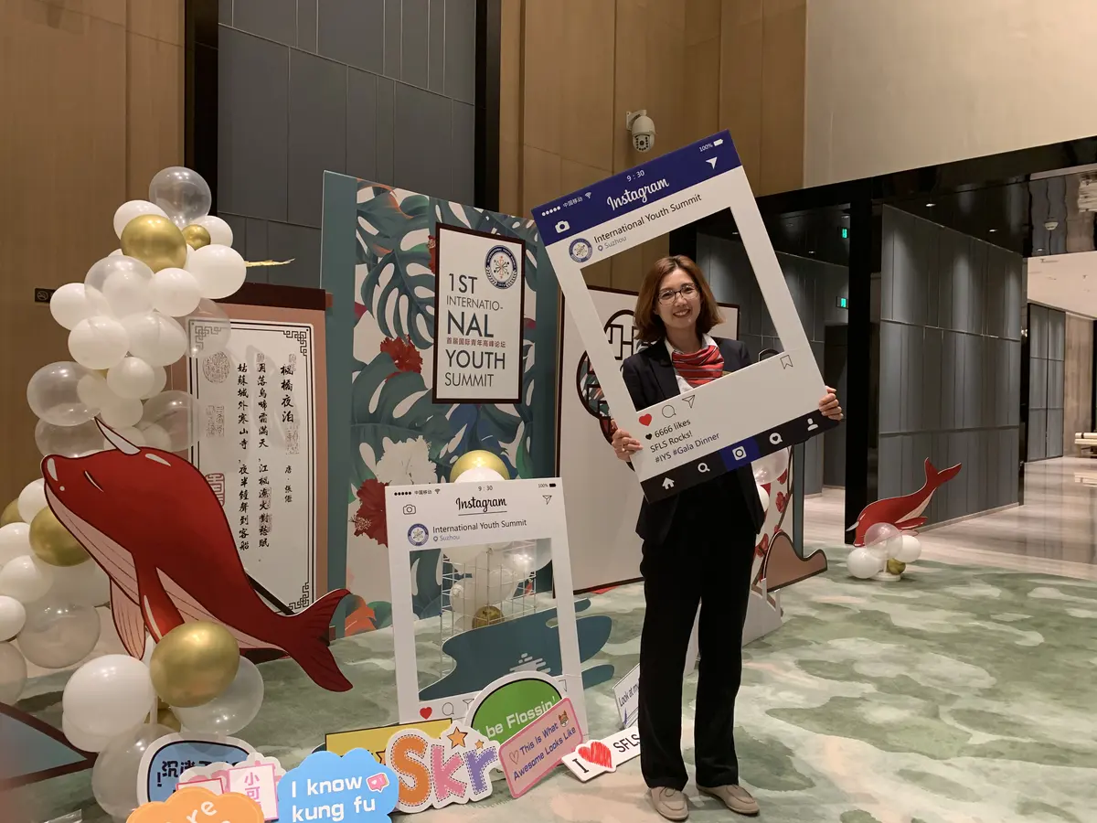 国际青年峰会活动参与者在主题展板前拍照留念