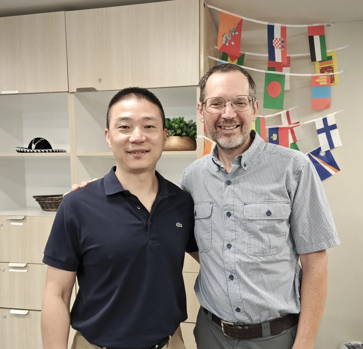 F²EDU CEO 殷宇峰与美国合作方代表在国际教育场景中合影